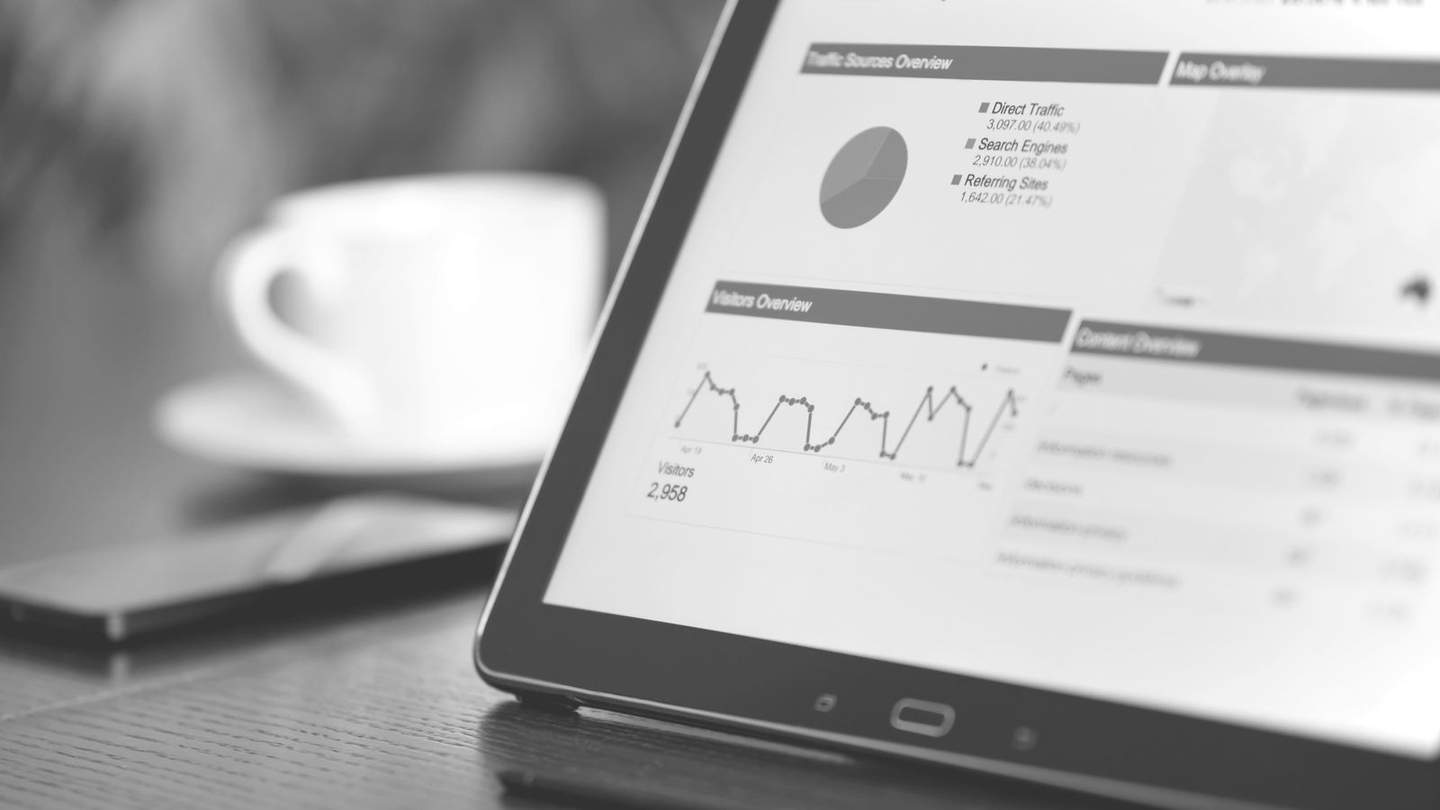 Close-up of a tablet screen showing a web analytics dashboard, in black and white