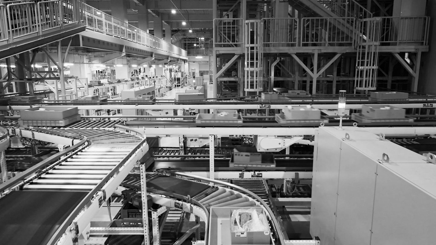 Detail of an automated conveyor and sortation system in a distribution facility, in black and white